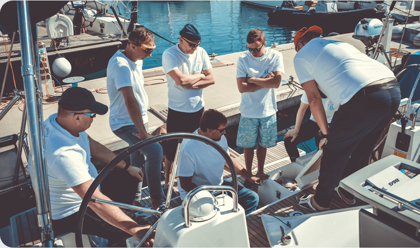 Grupa ludzi przygotowująca jacht przed kursem